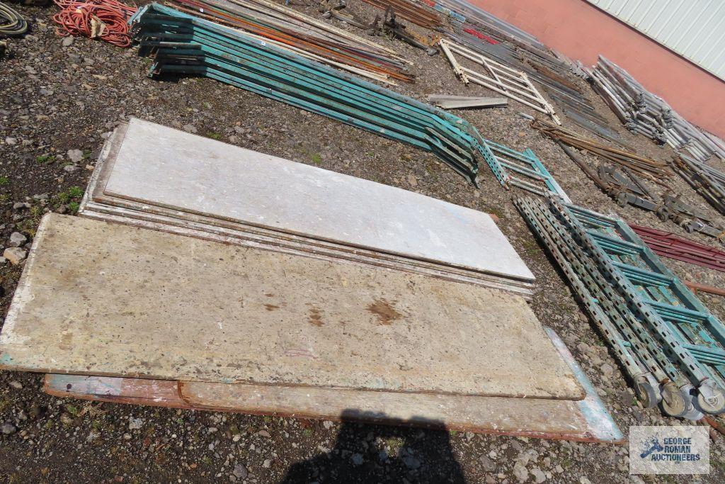 Lot of green roll about scaffolding pieces with boards