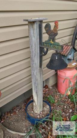 Rooster motif cast iron bell on wooden post with pan