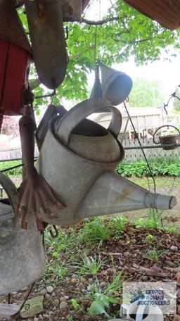 Lot of antique watering cans and birdhouse