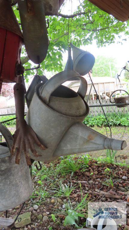 Lot of antique watering cans and birdhouse