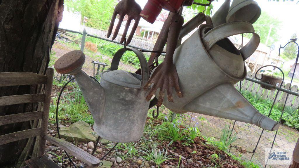 Lot of antique watering cans and birdhouse