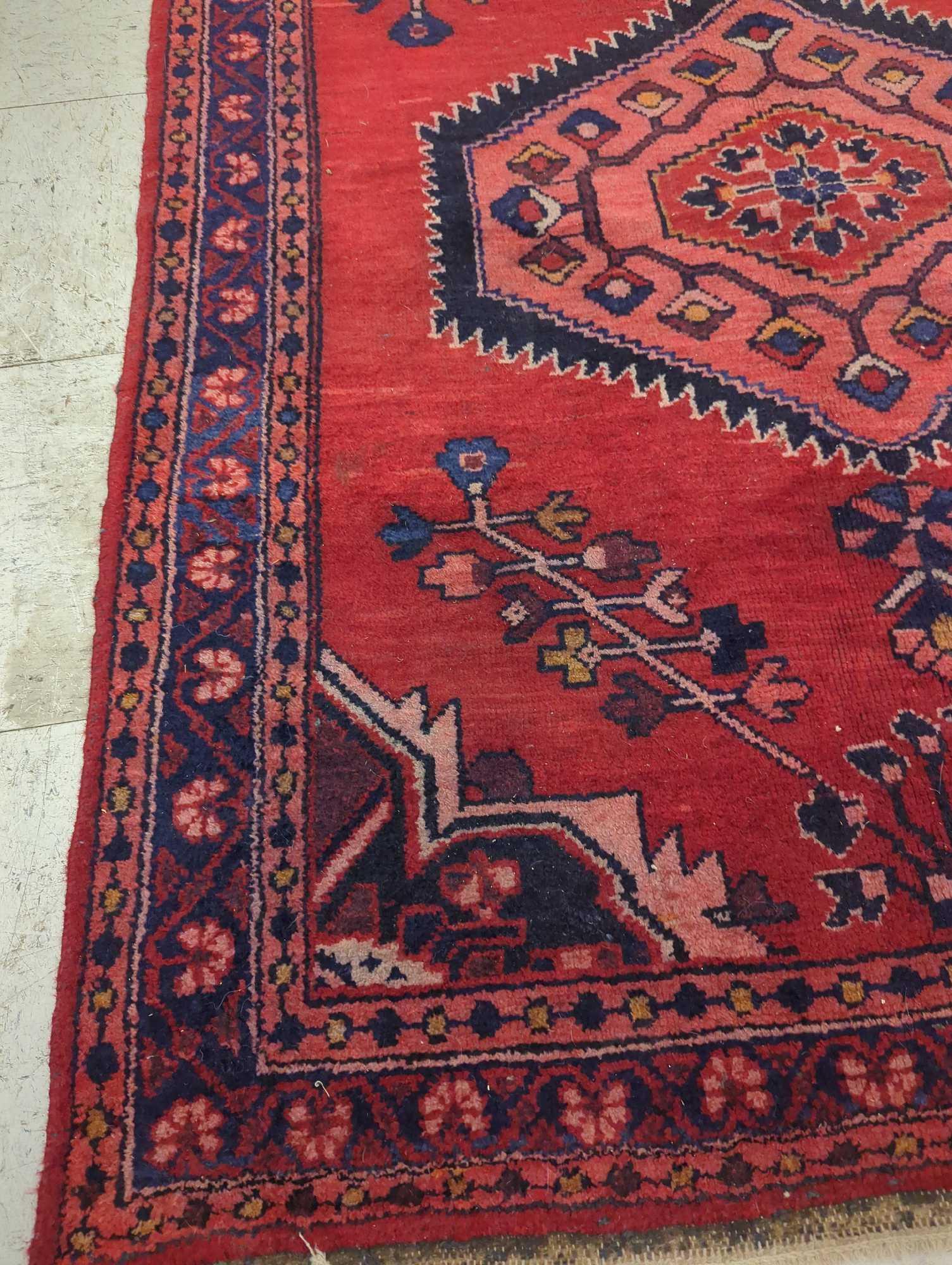 HAND MADE ANTIQUE AREA RUG. FLORAL ACCENTS, RED, AND DARK BLUE. 44 1/2"X60"