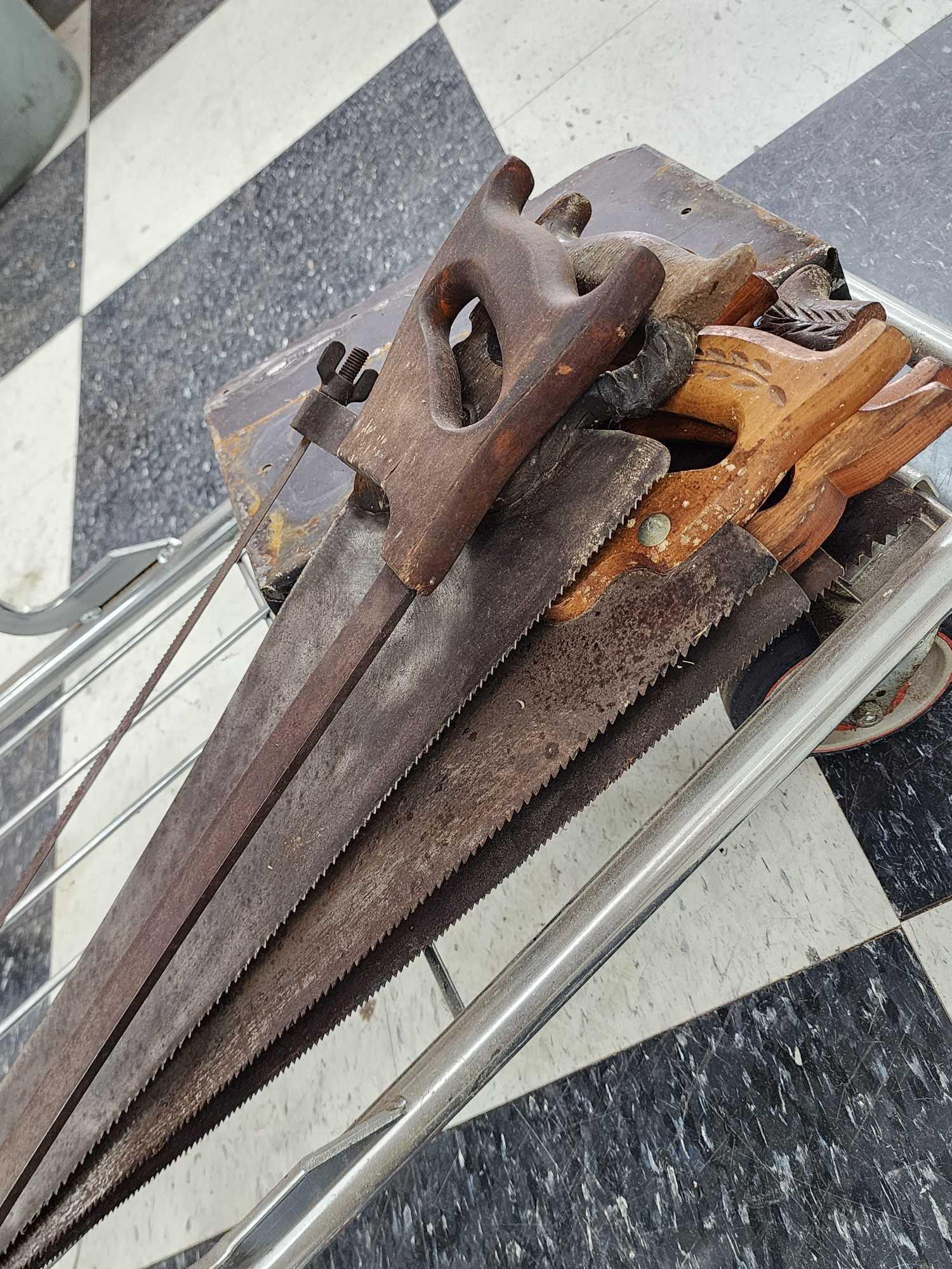 Cart full of vintage tools: hatchets, saws, wrenches, metal detector