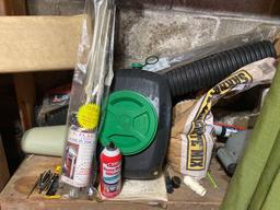 contents on wood shelf - gardening items - hedge trimmer - umbrella - misc