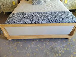 King size bed frame with padded sleigh style headboard and light wood trim